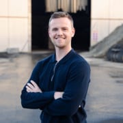 Medewerker van A. Jansen poseert buiten op industriële locatie, uitnodigend voor werken bij aJansen