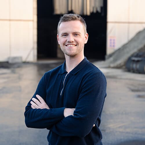 Medewerker van A. Jansen poseert buiten op industriële locatie, uitnodigend voor werken bij aJansen